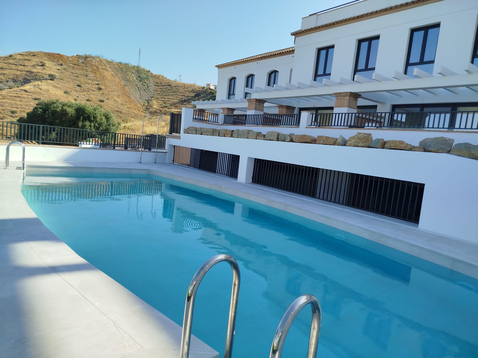 Infinitypool vid en lyxresort med utsikt över en kulle.